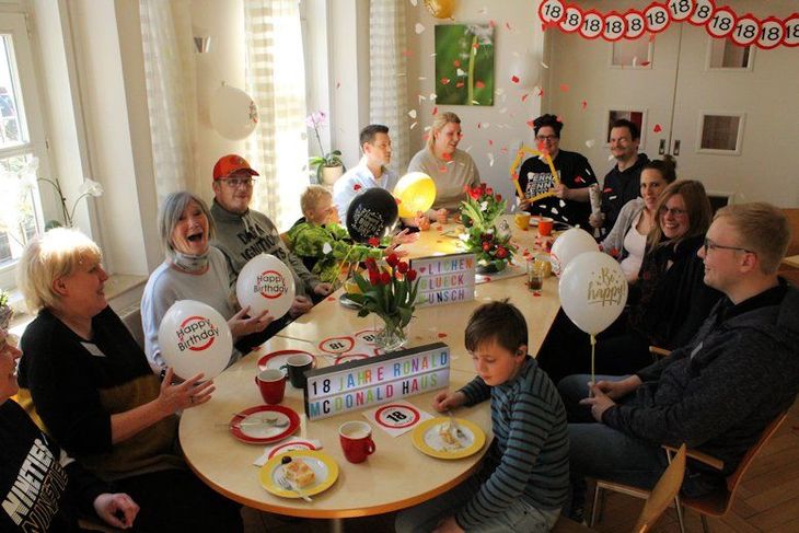 Eine fröhliche Geburtstags-Kaffeetafel mit Familien, Mitarbeiterinnen und Mitarbeitern. 